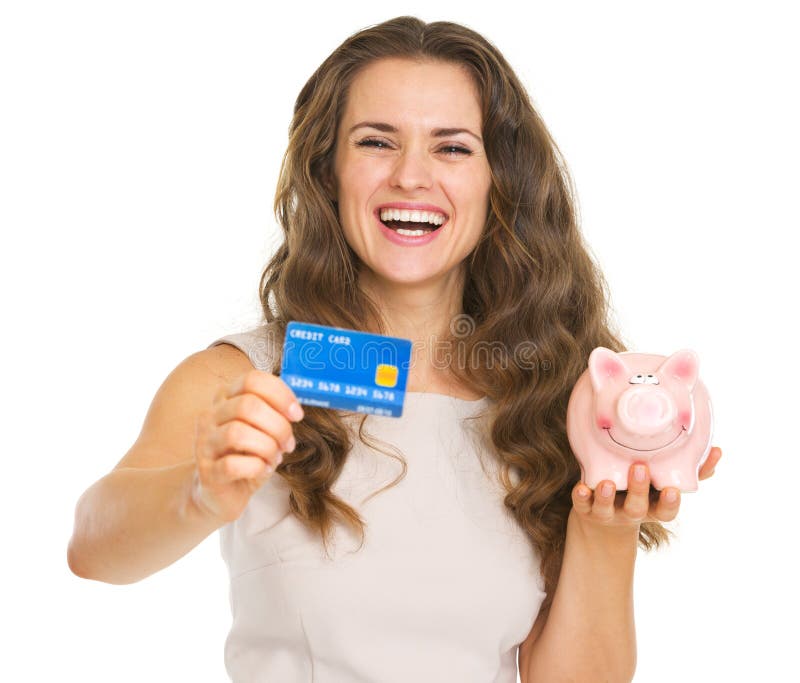 Happy woman showing credit card and piggy bank