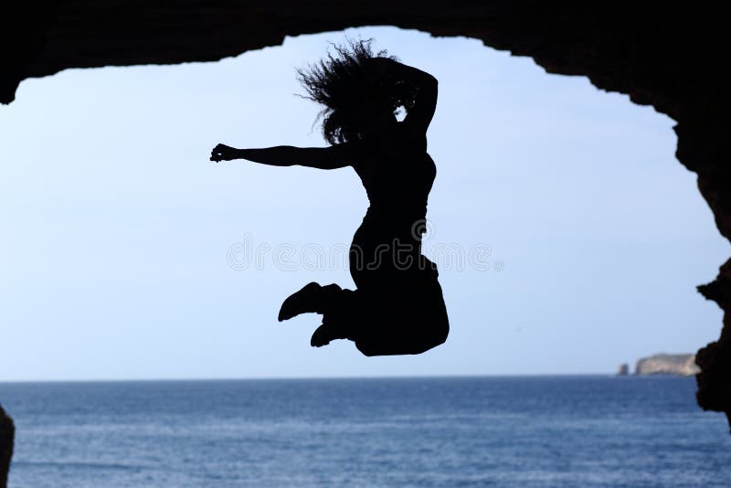 Happy woman silhouette jumping on the beach stock photos Happy woman silhouette jumping on the beach stock photos