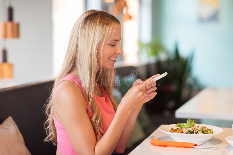 Happy woman with smartphone eating at restaurant royalty free stock photos Happy woman with smartphone eating at restaurant royalty free stock photos
