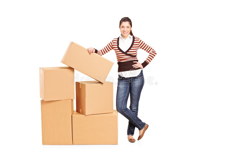 Happy woman standing by a bunch of boxes royalty free stock photography