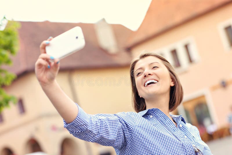 Šťastná žena s selfie v meste