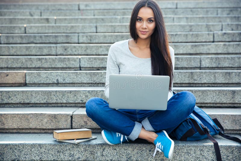 Happy woman using laptop computer outdoors