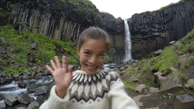 Happy Woman Waving Against Svartifoss Waterfall