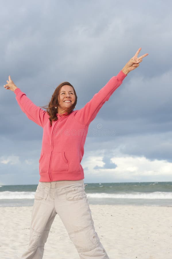 Happy woman in winning pose at beach