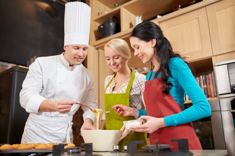 Happy women and chef cook baking in kitchen