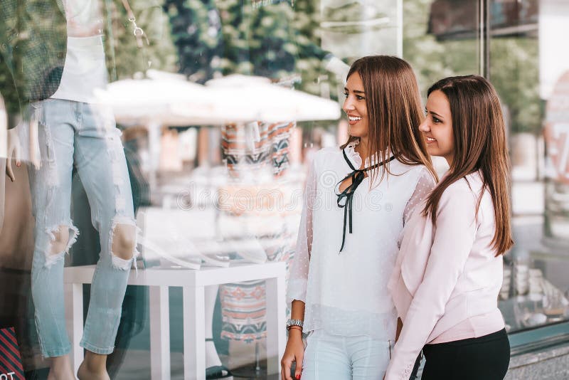 Happy women enjoy shopping while looking shop windows together royalty free stock photography Happy women enjoy shopping while looking shop windows together royalty free stock photography