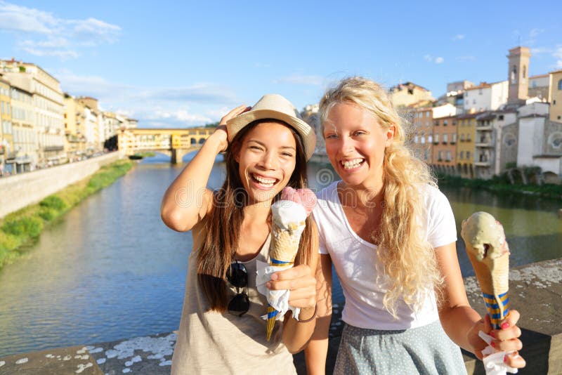 Happy women friends eating ice cream in Florence