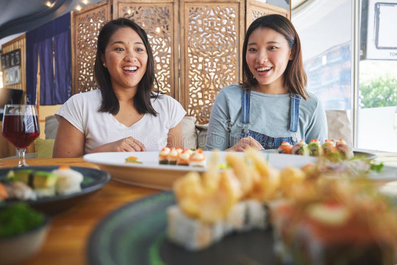 Happy women friends, sushi restaurant and eating with surprise, comic laugh, catering and plate. Japanese students, wow royalty free stock photo