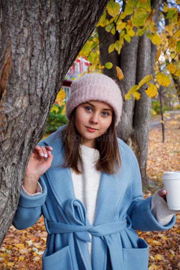 Happy young adult woman walking at beautiful autumn city street wearing warm hat royalty free stock photography Happy young adult woman walking at beautiful autumn city street wearing warm hat royalty free stock photography