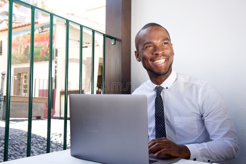 Happy young african american businessman working during lunch break at restaurant