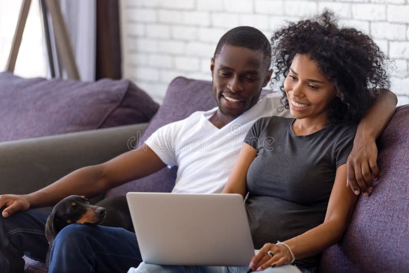 Happy black couple relax with dog watching movie on laptop stock photos Happy black couple relax with dog watching movie on laptop stock photos