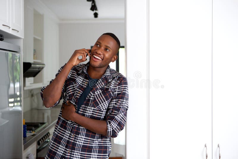 Happy Young African Guy at Home Making a Phone Call Stock Image - Image