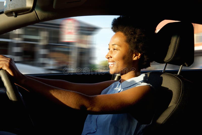 Happy young african woman driving a car stock image Happy young african woman driving a car stock image