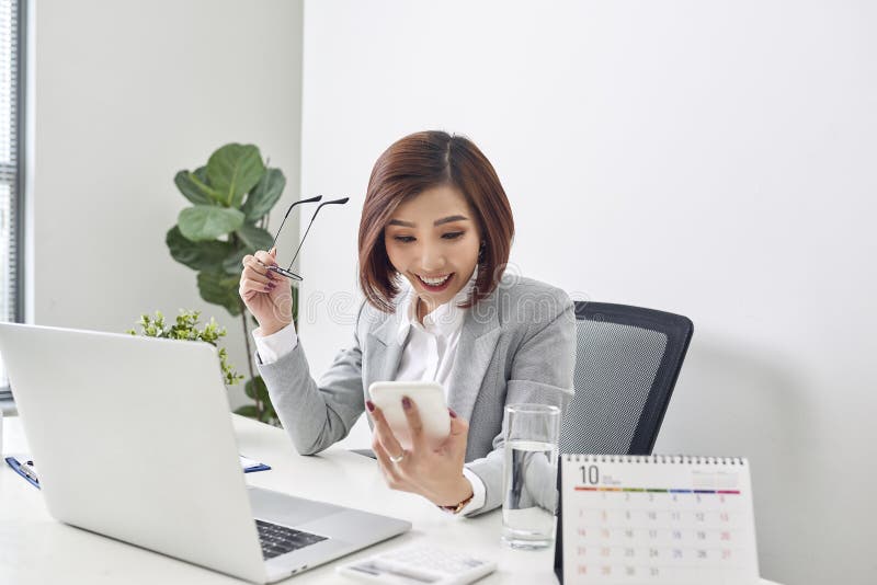 Happy young asian business woman finished her work at workplace stock photos Happy young asian business woman finished her work at workplace stock photos