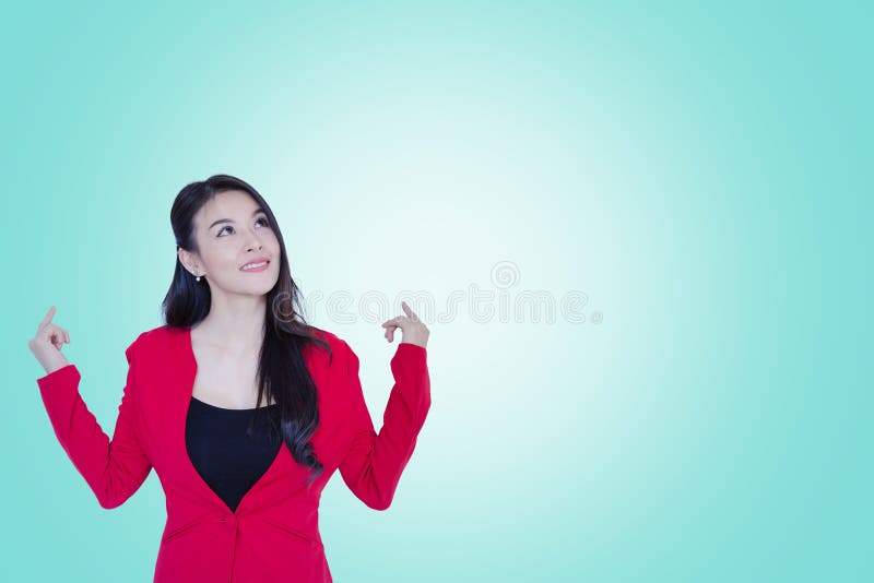 Happy young asian business woman red suit standing thinking on cyan color