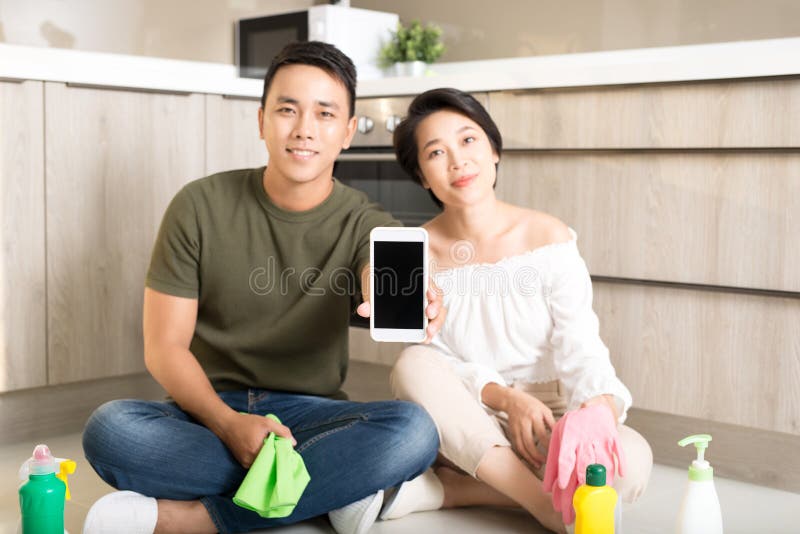 Happy Young Asian Couple Showing Smartphone while Cleaning House Stock ...