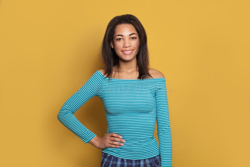 Happy young black woman on yellow studio background, fashion portrait stock photography Happy young black woman on yellow studio background, fashion portrait stock photography