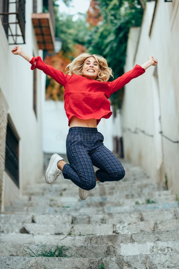 Happy young blond woman standing on beautiful steps in the street royalty free stock photo Happy young blond woman standing on beautiful steps in the street royalty free stock photo