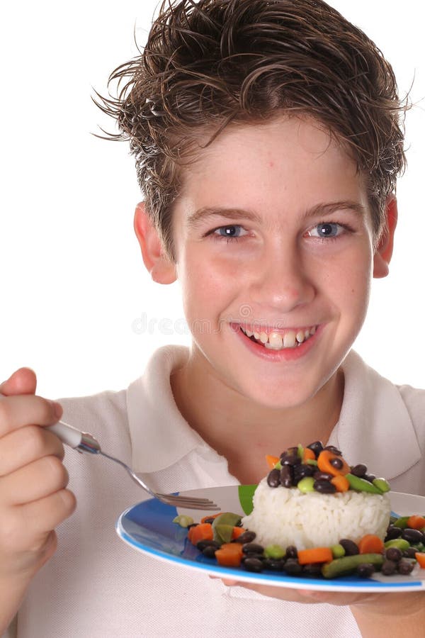 Happy young boy eating healthy rice, beans & veggi