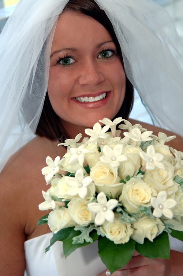 Happy young bride with rose bouquet