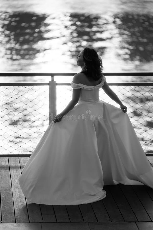 Happy Young Bride Woman in White Dress Running Summer Shooting Near a Happy Young Bride Woman in White Dress Running Summer Shooting Near a