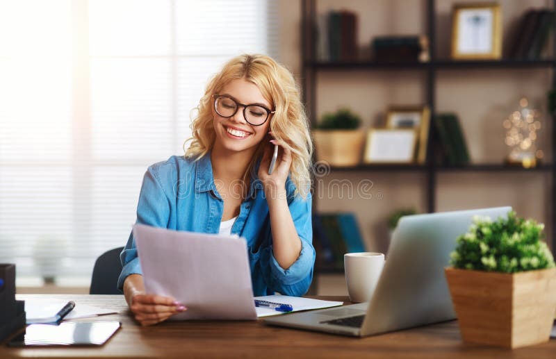 Happy young business woman at home office working on computer stock image Happy young business woman at home office working on computer stock image