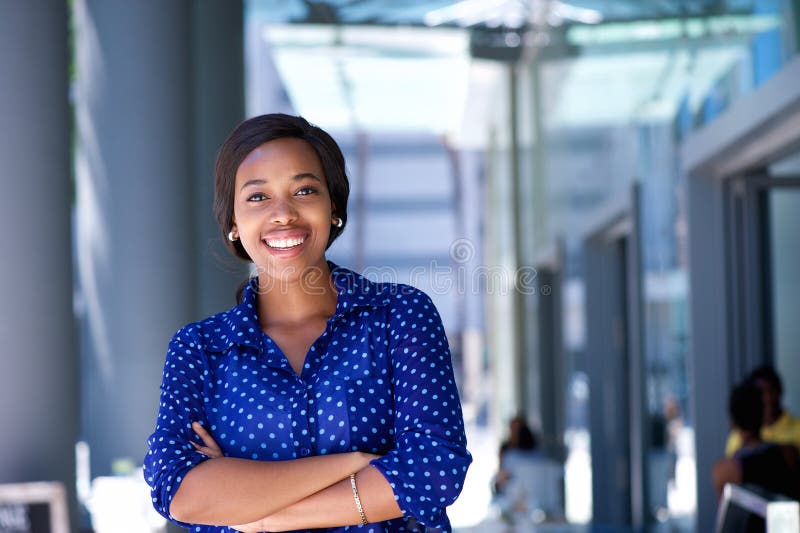 Happy young business woman standing outside office building