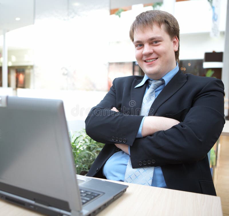 Happy young businessman with laptop