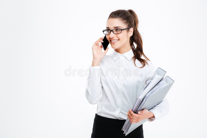 Happy young businesswoman holding folders and talking on mobile phone royalty free stock image Happy young businesswoman holding folders and talking on mobile phone royalty free stock image