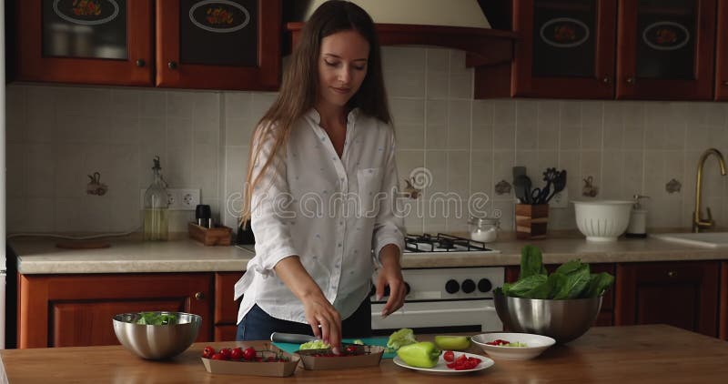 Happy Young Chef Mädchen, die frische Spinatblätter zum Salat beißen stock footage