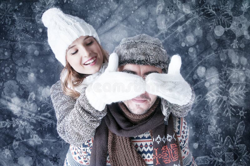 Happy young couple covering snow background.