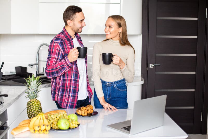 Happy young couple eating breakfast in the kitchen royalty free stock images