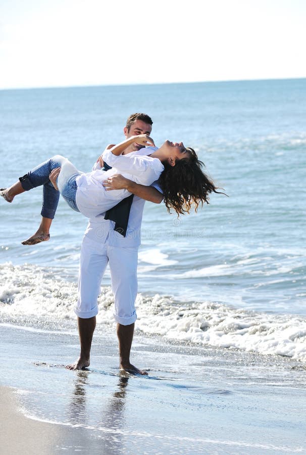 Lovely gay couple on piggyback ride at the beach. Stock Photo