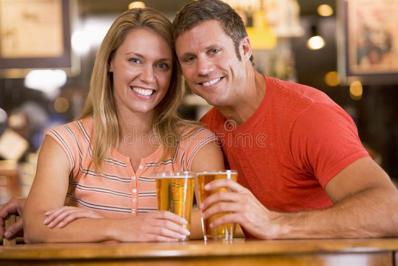 Happy young couple having beers at a bar royalty free stock images Happy young couple having beers at a bar royalty free stock images