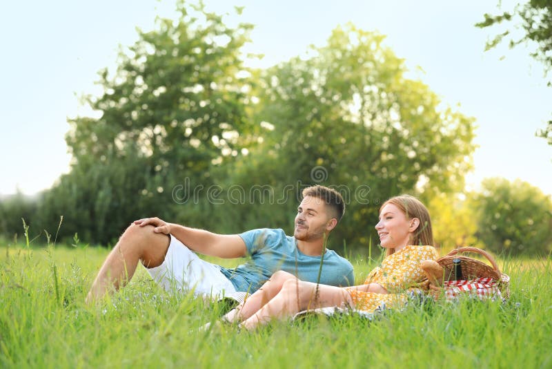 Happy young couple having picnic on green grass royalty free stock images Happy young couple having picnic on green grass royalty free stock images