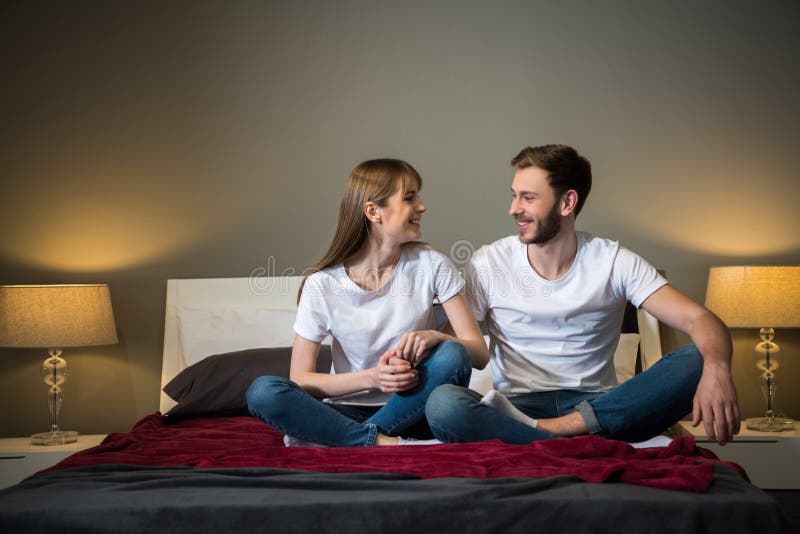 Happy Young Couple Holding Hands Of Each Other In Be