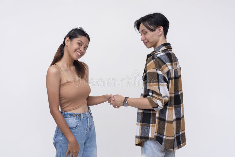 Happy young couple holding hands and smiling together stock photo