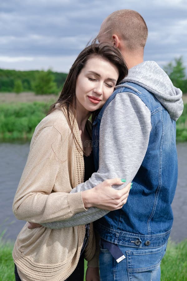 Happy Young Couple Outdoors Near Lake And Green Grass Bald Man And