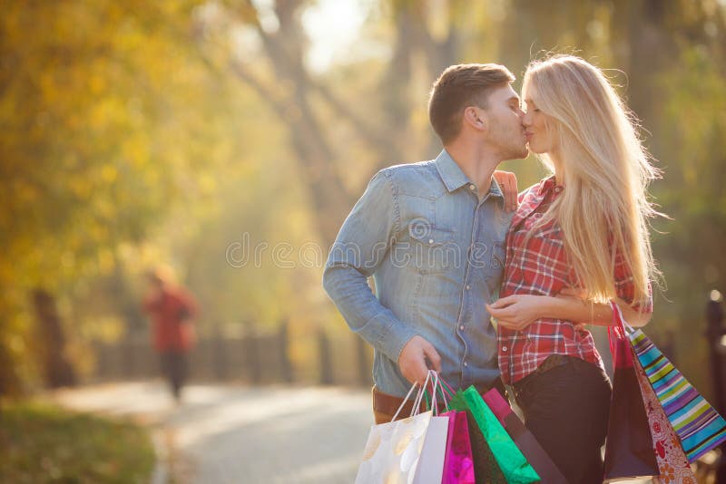 Happy young couple with a paper bag in the park.