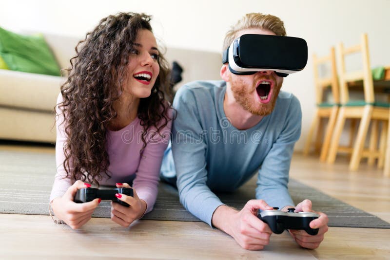 Happy young couple playing video games with virtual reality headsets royalty free stock photography Happy young couple playing video games with virtual reality headsets royalty free stock photography