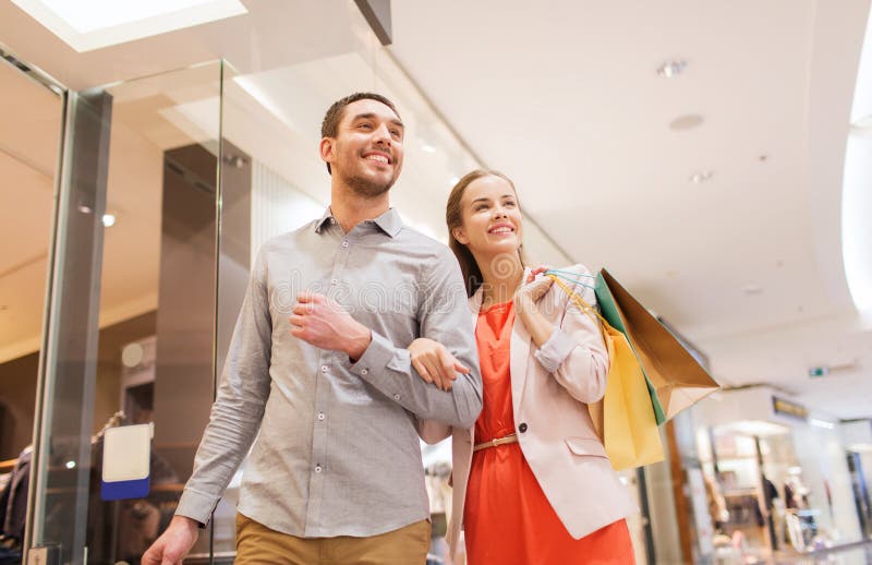 Happy young couple with shopping bags in mall