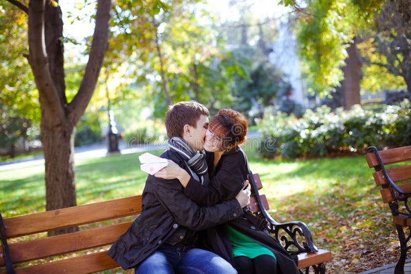 Happy young couple sitting on a park bench