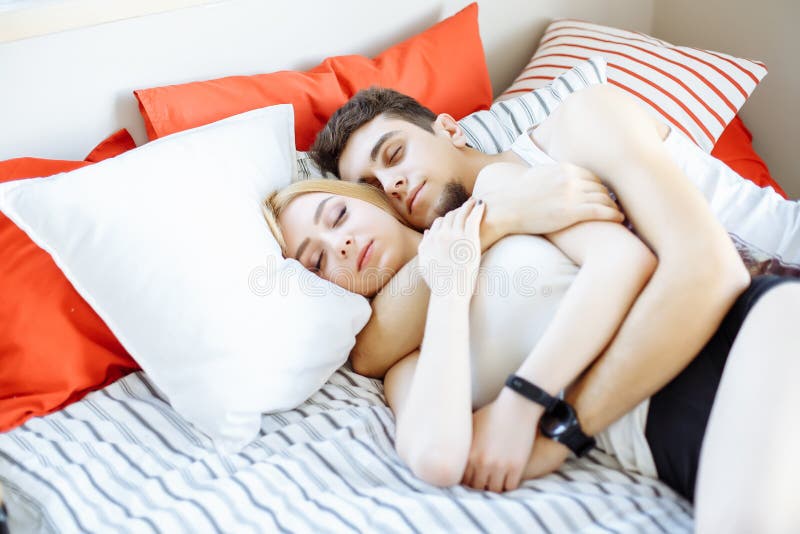 Happy Attractive Couple Hugging And Sleeping On Bed At Night