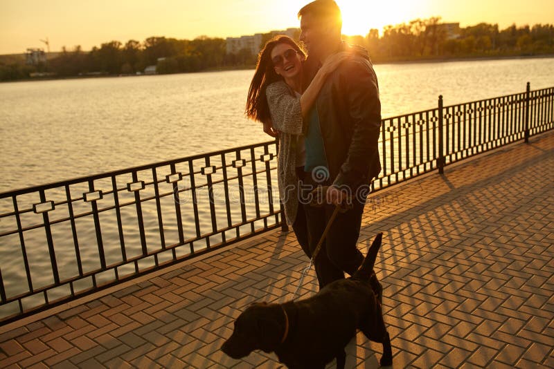 Happy young couple walking with dog on street. stock image Happy young couple walking with dog on street. stock image