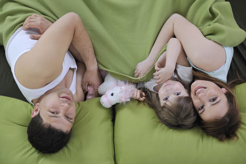 Happy young family eat breakfast in bed