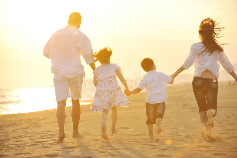 Happy young family have fun on beach at sunset