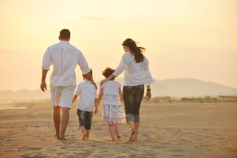 Happy young family have fun on beach at sunset