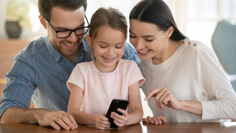 Happy young family with child using cellphone together