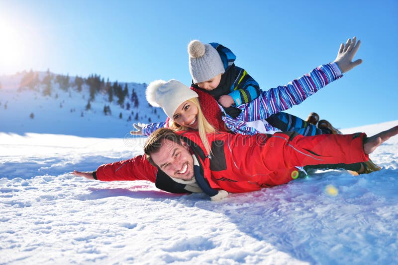 Happy young family playing in fresh snow at beautiful sunny winter day outdoor in nature. Caucasian, outdoors.