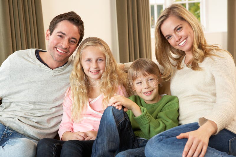 Happy young family sitting on sofa stock photo Happy young family sitting on sofa stock photo